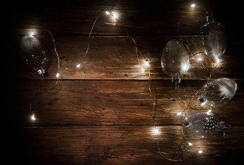 Christmas New Year eve background with decoration on wooden board, glare of light, text space