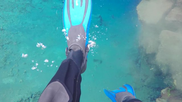 Kicking fins while snorkeling in the Silfra Fissure in Iceland between the North American and Eurasian tectonic plates.