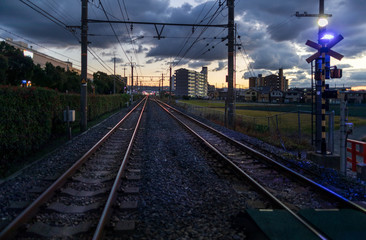 Fototapeta na wymiar Dramatic sunset over rail tracks vanishing into point at station