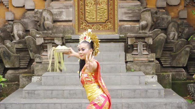Balinese female dancer performing artistic dance in colorful costume. Shot in 4K in Bali, Indonesia 