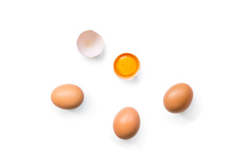 fresh brown organic chicken eggs broken with yolk and egg white isolated on white background. Vertical composition. Top view