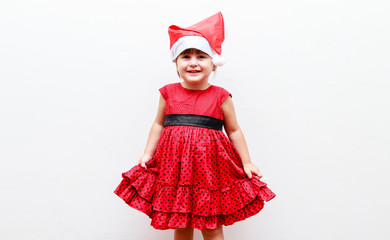 portrait of caucasian toddler girl with christmas hat, white background