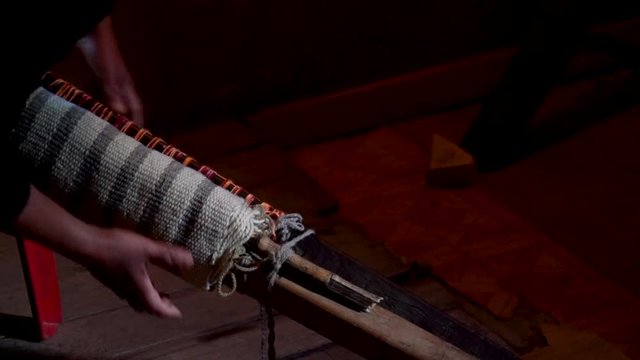 Hands finishing a weaving work on rustic loom. Trapa Trapa Alto Biobio. Chile. Flat plane