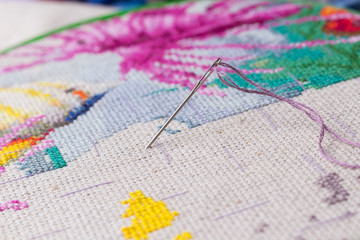 The process of working on a piece of embroidery.