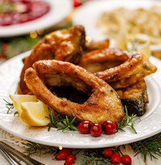 Christmas carp, Fried carp fish slices on a white plate, close up. Traditional christmas eve dish. Polish Christmas