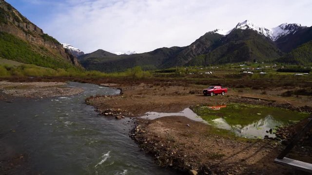 Beautiful mountainscape with a river stream and a parked red pickup truck. Trapa Trapa region Alto Biobio Chile. Flat plane