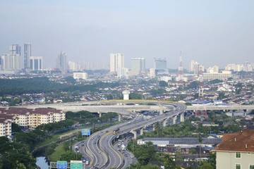 Aerial view of Johor Bahru's cityscape with highways and vehicles on a hazy foggy morning 