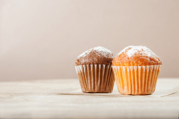 Lemon and chocolate muffins on a wooden table. Space for text. - obrazy, fototapety, plakaty