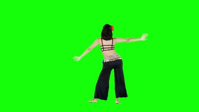 Back view of a woman performing belly dancing over green screen
