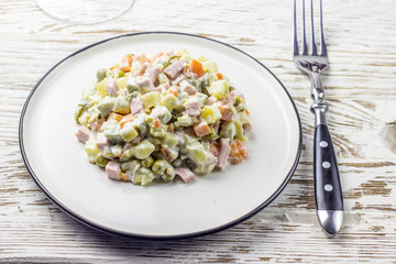 Russian traditional salad Olivier with vegetables and meat. Winter salad