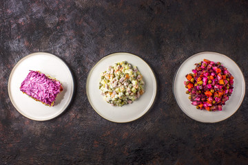 Russian food on dark background. Assortment salad of Russian cuisine - Olivier salad, vinaigrette -...