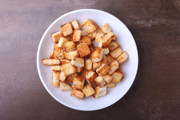 Delicious crispy croutons, crumbs of bread in white plate. ready for cooking.