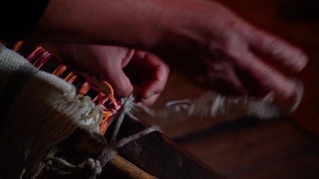 Hands untying natural wool work on rustic loom. Trapa Trapa Alto Biobio. Chile. Flat plane