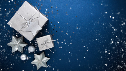 Christmas and New Year holiday background. Xmas greeting card. Christmas silver gifts on blue background top view. Flat lay