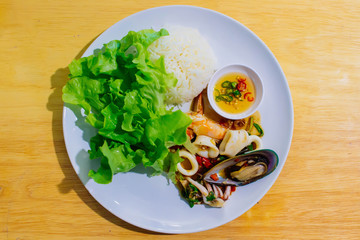 Rice topped with stir-fried sea food and basil.