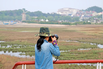 A female photographer was photographing in a wetland park, china