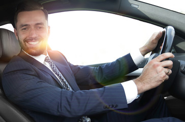 portrait of confident businessman driving a car