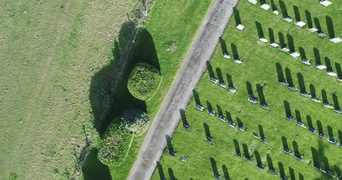 Flying high above the sky. 4K drone footage. In Somerset UK. Fields in sunset. Drone birds eye view shot of grave yard.