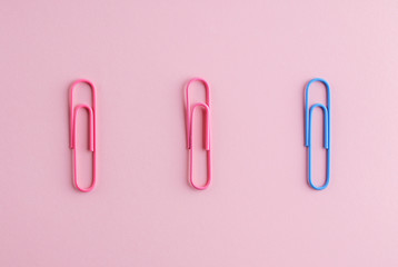 Colored paper clips on a pink background.