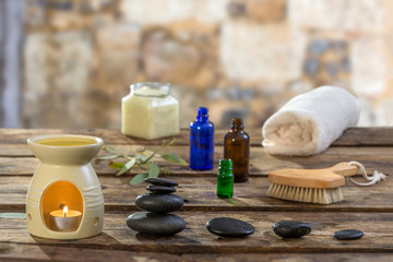 Spa concept: zen stones, candles and flowers against old stone wall on the background