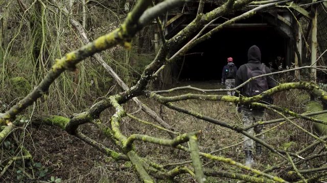 Two young men entering an abandoned tunnel. Eisborn Germany. Flat plane