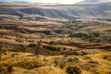  Hilly valley, with small villages and yellowed autumn rural fields, located in the mountains Geghama ridge
