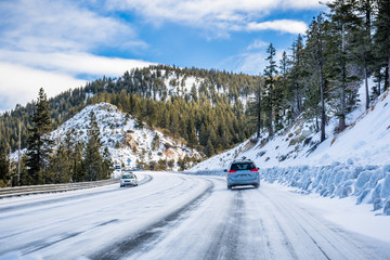 Driving on an ice and snow covered road through the Sierra mountains on a sunny day, Nevada