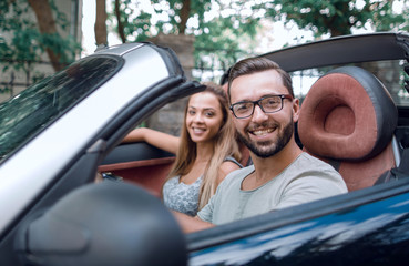 young man driving a convertible car