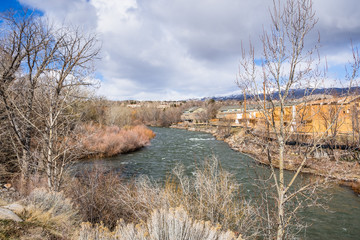Truckee River flowing through a residential neighborhood in Reno, Nevada; snow covered mountains in the background