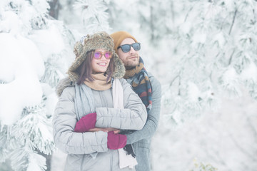 Fototapeta na wymiar Young couple holding each other in snow outdoors