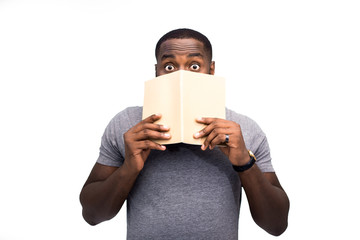 Oh my god! Young black student isolated on white studio background surprised and having shocked face effect regarding exam results in his test on work exercise book. Education and studying concept