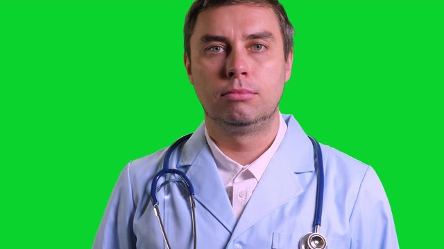 Young doctor stand and smile on green chroma key background