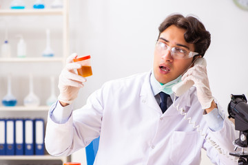 Young handsome chemist working in the lab