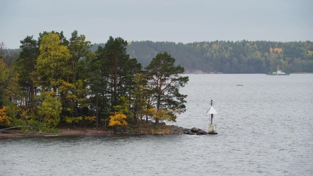 A closer look of the white lamp on the edge in Stockholm Sweden from the rock island with the trees on the side