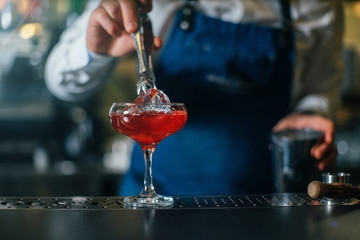 Bartender professionally working with om making drinks and cocktails