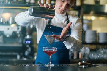 Bartender professionally working with om making drinks and cocktails