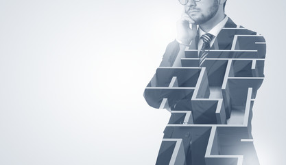 Young businessman in suit standing with maze graphic 