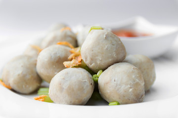 Boiled pork balls with sweet spicy sauce in white plate
