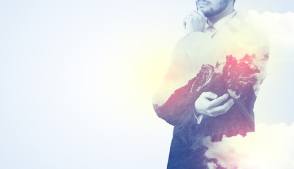 Businessman standing and thinking with snowy mountain graphic