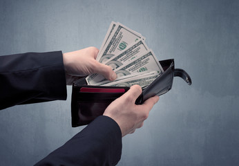Businessman's hand in suit takes out dollar money from a wallet
