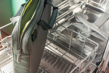 Large bag from the laptop lies in the lower compartment of the dishwasher