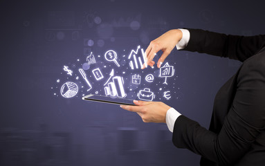 Elegant hand holding tablet with chalk drawn social media symbols above
