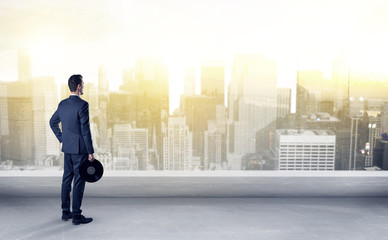 Businessman standing with his back on a roof with objects in his hand
