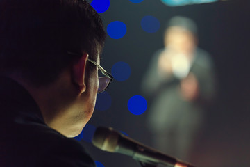 Speaker giving a talk on corporate Business Conference hall or seminar room background.