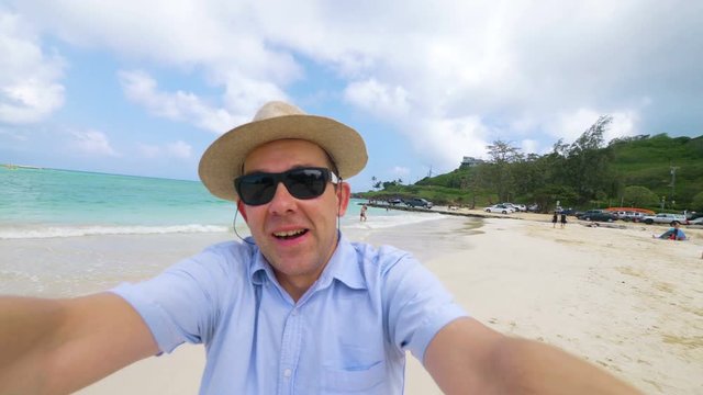 Happy man taking a selfie in Hawaiian beach in 4k slow motion  60fps