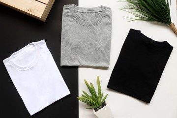 black , gray , white t-shirts with wood box and cactus. rustic background