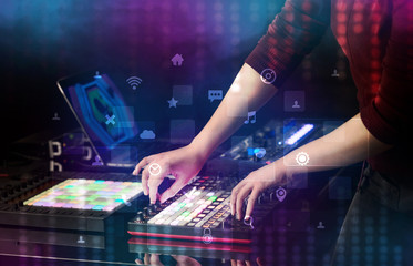 Hand mixing music on dj controller with social media concept icons
