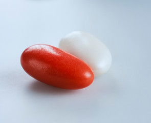 A couple of red and white candy-coated almonds