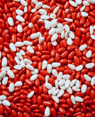 Fototapeta na wymiar Large group of red and white candy-coated almonds still life
