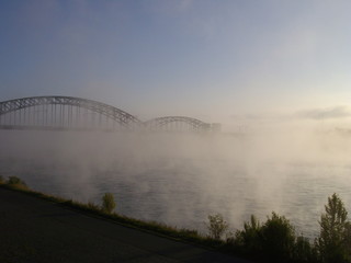 Fototapeta na wymiar Sonnenaufgang im Nebel über dem Fluss (Rhein)